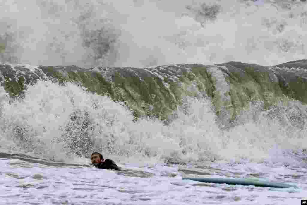 Max Von Frangenberg gets hit by a wave as he attempts to surf high waves caused by Hurricane Ian in Tybee Island, Georgia, U.S.