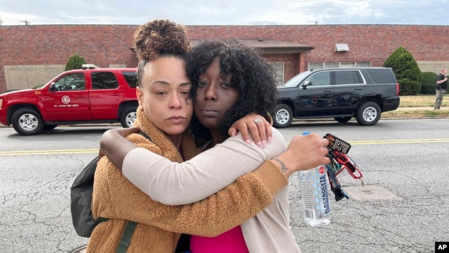 Janay Douglas, a la izquierda, y Renada Bridgett, a la derecha, en el exterior de Central Visual and Performing Arts High School en St. Louis, donde ocurrió el tiroteo el lunes 24 de octubre de 2022.