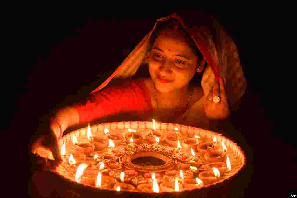 A woman lights earthen lamps on the occasion of Diwali, the Hindu festival of lights, at her house in Guwahati, India.