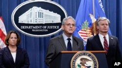 Minis Jistis Merrick Garland (mitan) ak Minis Jistis Adjwen Lisa Monaco (goch) epi e FBI Christopher Wray, pandan yon konferans pou lapres nan Washington, 24 Oktob, 2022. 