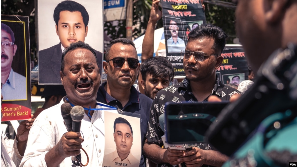 A man holding a photo of his brother, an alleged victim of an enforced disappearance, is overcome with emotions during a rally in Dhaka, Aug. 30, 2022. At the rally, families of dozens of victims turned up with photos of missing activists. (Abdur Rajjak/VOA)