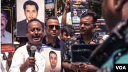 A man holding a photo of his brother, an alleged victim of an enforced disappearance, is overcome with emotions during a rally in Dhaka, Aug. 30, 2022. At the rally, families of dozens of victims turned up with photos of missing activists. (Abdur Rajjak/VOA)