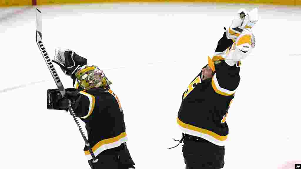Boston Bruins goaltender Jeremy Swayman, left, celebrates with Linus Ullmark after defeating the Detroit Red Wings 5-1, following an NHL hockey game, Oct. 27, 2022, in Boston.