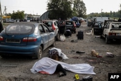 Bodies of people killed in a Russian missile attack lie on a road near the city of Zaporizhzhia, Ukraine, Sept. 30, 2022. Russia now claims Ukraine's Zaporizhzhia region as its own.
