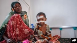 Malnourished Kalson Hussein, 4, sits next to her mother Isho Shukria, 35, at the Martini hospital where she is being treated in Mogadishu, Somalia, Sept. 3, 2022.