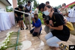 Kerabat dan teman-teman meletakkan bunga untuk memperingati korban tewas dalam serangan di pusat penitipan anak Uthai Sawan, timur laut Thailand, Jumat, 7 Oktober 2022. (Foto: AP)