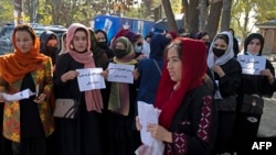 Perempuan Afghanistan memegang kertas bertuliskan slogan dalam protes di depan Kabul University di Kabul pada 18 Oktober 2022.