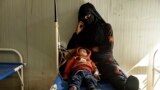 A mother sits with her child who was diagnosed with cholera in a hospital in Deir el-Zour, Syria, Sept. 29, 2022. 