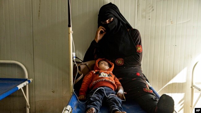 A mother sits with her child who was diagnosed with cholera in a hospital in Deir el-Zour, Syria, Sept. 29, 2022.