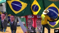 ARCHIVO - Retratos del presidente Jair Bolsonaro, a la izquierda, y del exmandatario Luiz Inácio Lula da Silva, al centro, cuelgan en el exterior de al Corte Suprema Electoral en Brasilia, el 5 de septiembre de 2022. 