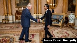 Le roi Charles III reçoit Rishi Sunak lors d'une audience au palais de Buckingham, à Londres, où il a invité le chef nouvellement élu du Parti conservateur à devenir Premier ministre et à former un nouveau gouvernement, mardi 25 octobre 2022. 