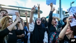 FILE - People shout slogans during a protest against the death of Iranian Mahsa Amini, in Istanbul, Turkey, Oct. 2, 2022. 