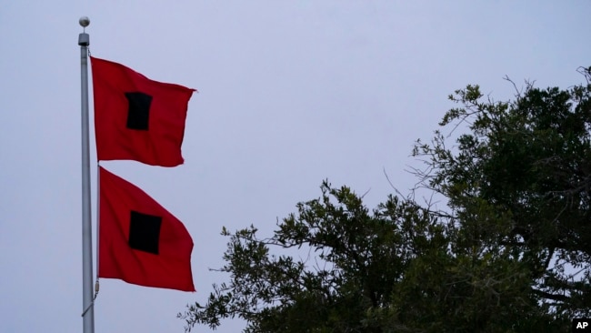 Las banderas de advertencia de huracán ondean frente a la estación de bomberos y el ayuntamiento cuando se sienten los efectos del huracán Ian, el jueves 29 de septiembre de 2022, en Sullivan's Island, Carolina del Sur (AP Photo/Alex Brandon)