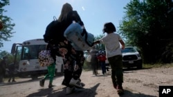 FILE - A migrant family from Venezuela walks to a Border Patrol transport vehicle after they and other migrants crossed the U.S.-Mexico border and turned themselves in June 16, 2021, in Del Rio, Texas. (AP Photo/Eric Gay, File)