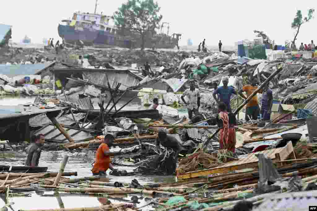 People search for their belongings amid the damage of their collapsed houses after the ocean torm Sitrang hit in Chittagong, Bangladesh.
