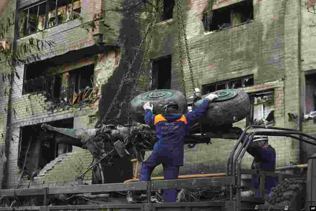 Emergency workers load broken remains of a warplane on a vehicle at the site of a plane crash in in Yeysk, Russia. At least 15 people died from the crash of a Russian warplane into a nine-story apartment building.