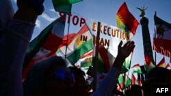 FILE - Protesters hold up a placard reading "Stop Execution in Iran" as they take part in a rally in support of the demonstrations in Iran, in front of the Victory Column (Siegessaeule) in Berlin, Oct. 22, 2022. Three men were injured Oct. 30 when a pro-d