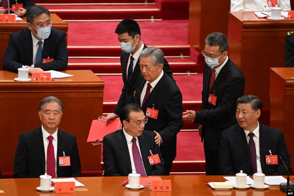 2022年10月22日，在北京人民大会堂举行的中共二十大闭幕式上，习近平看着前中共总书记胡锦涛被警卫扶着离席时拍了一下中国总理李克强的臂膀。(photo:VOA)