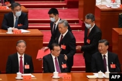 2022年10月22日，在北京人民大会堂举行的中共二十大闭幕式上，习近平看着前中共总书记胡锦涛被警卫扶着离席时拍了一下中国总理李克强的臂膀。