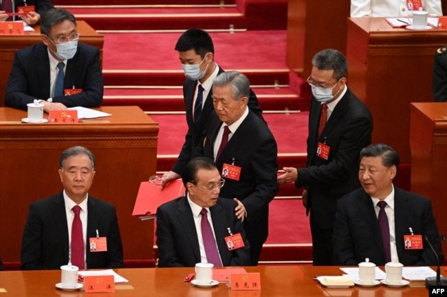 2022年10月22日，在北京人民大会堂举行的中共二十大闭幕式上，习近平看着前中共总书记胡锦涛被警卫扶着离席时拍了一下中国总理李克强的臂膀。