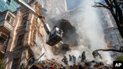 Firefighters work after a drone attack on buildings in Kyiv, Ukraine, Oct. 17, 2022. 