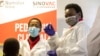 FILE - A health care worker holds a Sinovac vaccine before vaccinating a minor receives in Pretoria, South Africa, Sept. 10, 2021. 