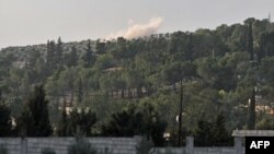 Smoke rises in the horizon as Hayat Tahrir al-Sham (HTS) jihadist group's advance toward Syrian opposition-held areas in the northern Aleppo province on Oct. 17, 2022.