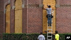 Workers from Specialized Performance Delivered 24:7 board up the windows on the historical Henry B. Plant Hall on the campus of the University of Tampa ahead of Hurricane Ian, Sept. 27, 2022, in Tampa, Fla.