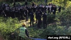 Policijski kordon između aktivista i radnika kineske kompanije CRBC koji postavlja ogradu u sklopu pripreme za izgradnju mosta preko Dunava, na Šordošu, u Novom Sadu, 18. oktobra 2022. (Foto: Radio Slobodna Evropa)