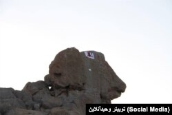 نصب بنر اعتراضی بر فراز قله الوند در استان همدان