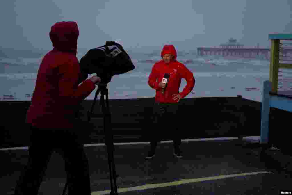 A TV crew broadcasts from the beach at Fort Myers ahead of Hurricane Ian, in Fort Myers, Florida, Sept. 28, 2022.