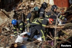 Rescuers extract a body from a residential building destroyed by a Russian drone strike, which local authorities consider to be Iranian-made Shahed-136 unmanned aerial vehicles (UAVs), in Kyiv, Ukraine, Oct. 17, 2022.