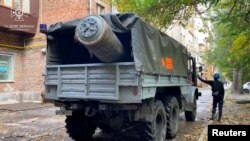 在乌克兰扎波罗热，一辆紧急事务车辆装载着俄罗斯导弹的残骸。（2022年10月21日）