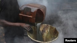 FILE - A man pours crude oil into a funnel at an illegal oil refinery in Bayelsa state, Nigeria, Nov. 25, 2012. Nigerian National Petroleum Corporation officials said Oct. 18, 2022, that a crackdown had significantly cut the scale of oil theft in the Niger Delta.
