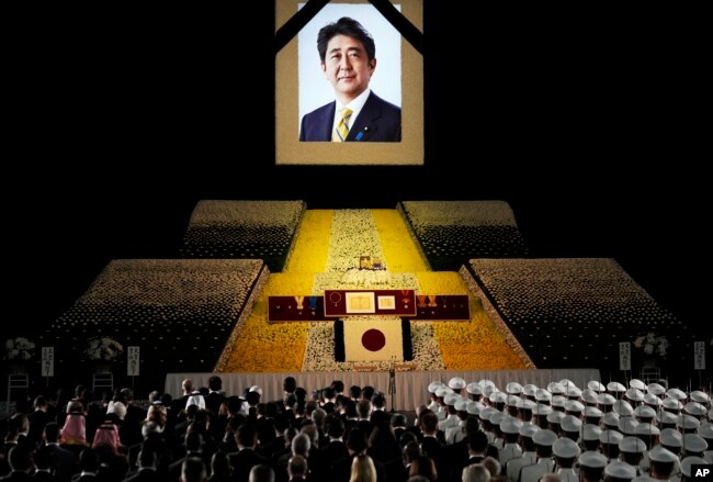 A portrait of former Japanese Prime Minister Shinzo Abe hangs on the stage during his state funeral, Tuesday, Sept. 27, 2022, Tokyo. Abe was assassinated in July. (Franck Robichon/Pool Photo via AP)