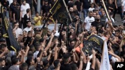Mourners carry the body of Matin Dababa, draped in the flag of the Islamic Jihad militant group, at his funeral in the Jenin refugee camp, in occupied West Bank, Oct. 14, 2022.