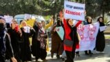 Women carry placards and chant slogans during a protest they call "Stop Hazara Genocide," a day after a deadly suicide bomb attack at a learning center, in Kabul, Afghanistan, Oct. 1, 2022.