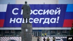 ယူကရိန္းႏိုင္ငံ၊ Luhansk ၿမိဳ႕မွာ “႐ုရွားနဲ႔အတူ အၿမဲထာဝရ” စာတန္းကို ဖတ္ေနဟန္ ႐ုရွားျပည္ေထာင္စုတည္ေထာင္သူ Vladimir Lenin ရဲ႕႐ုပ္တုကို ေတြ႔ျမင္ရပံု။ (စက္တင္ဘာ ၂၈၊ ၂၀၂၂)