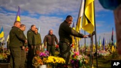 Українські військові покладають квіти до могили нещодавно вбитого солдата, Харківська область, 14 жовтня 2022 року