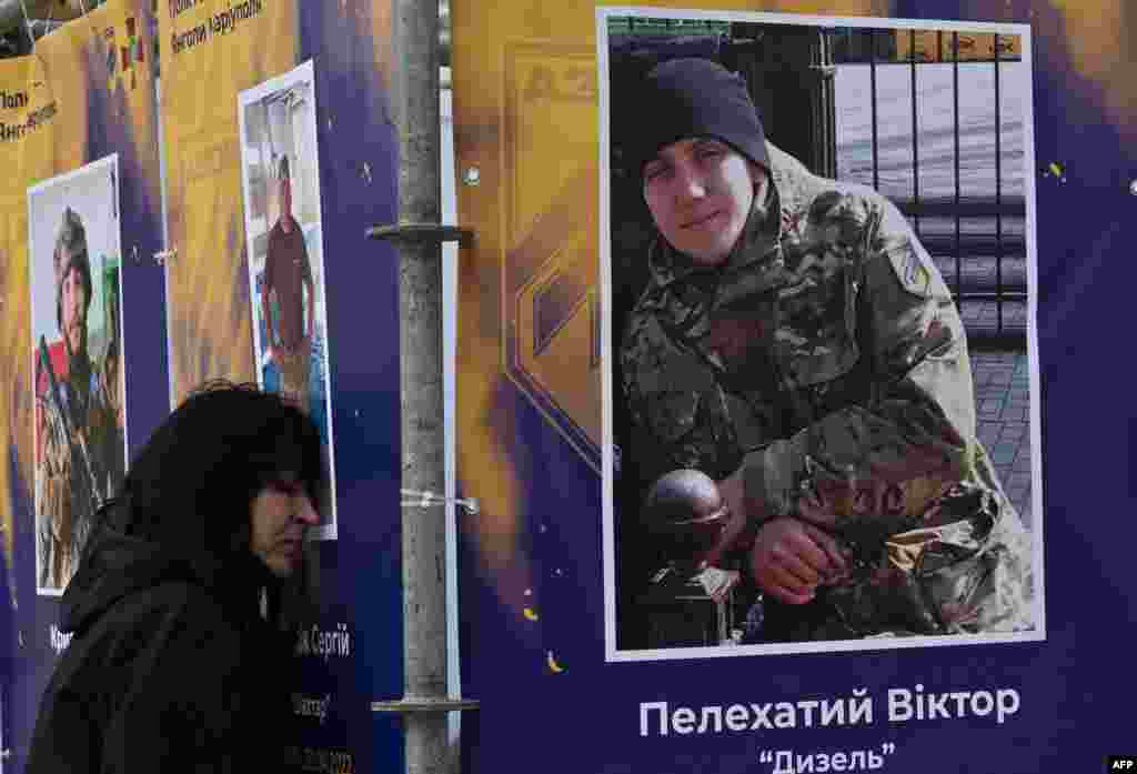 A relative of a dead serviceman reacts at his portrait during the opening of an open-air exhibition "Azov Regiment — Angels of Mariupol" in the center of Kyiv to mark Ukraine's Defenders Day, amid the Russian invasion of Ukraine.