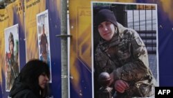 A relative of a dead serviceman reacts at his portrait during the opening of an open-air exhibition "Azov Regiment — Angels of Mariupol" in the center of Kyiv to mark Ukraine's Defenders Day, amid the Russian invasion of Ukraine.