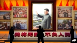 A portrait of Chinese President Xi Jinping is displayed near the words 'I will put aside my own well-being for the good of my people' at the Museum of the Communist Party of China in Beijing, Oct. 12, 2022.