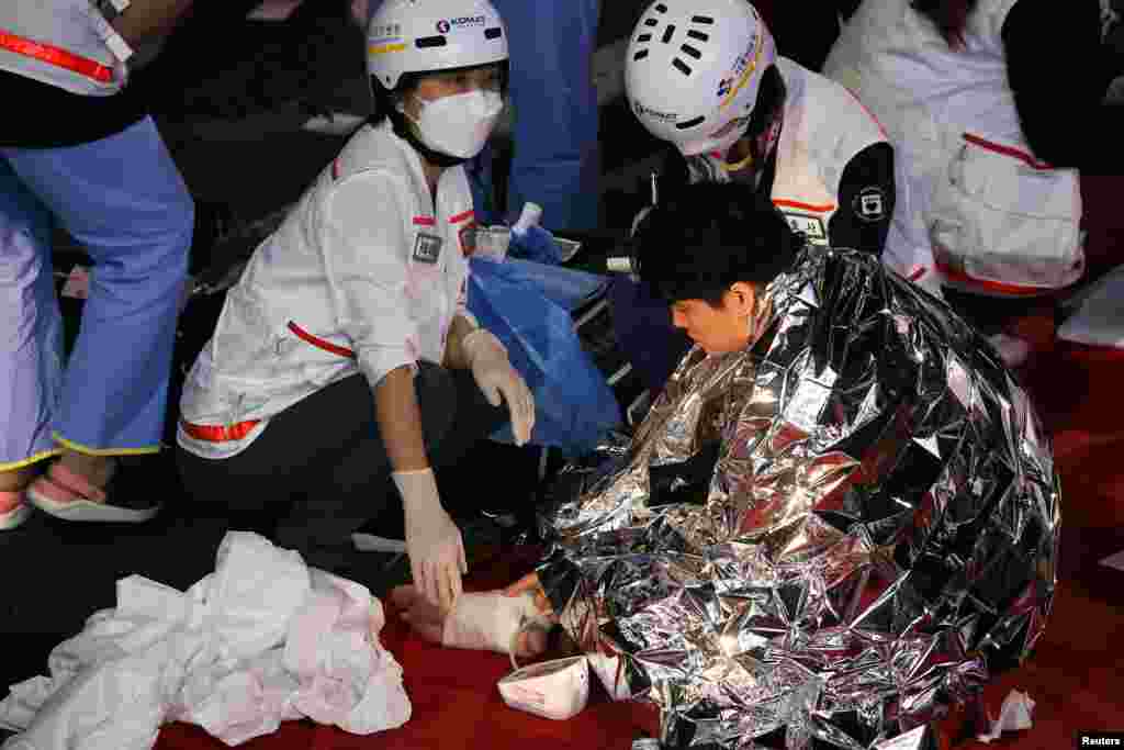 A man receives medical help from rescue team members at the scene where dozens of people were injured in a stampede during a Halloween festival in Seoul, South Korea, Oct. 30, 2022.