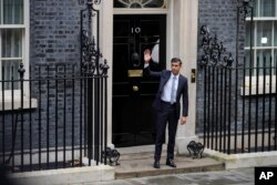 New British Prime Minister Rishi Sunak waves after arriving at Downing Street in London, Oct. 25, 2022, after returning from Buckingham Palace where he was formally appointed to the post by Britain's King Charles III.