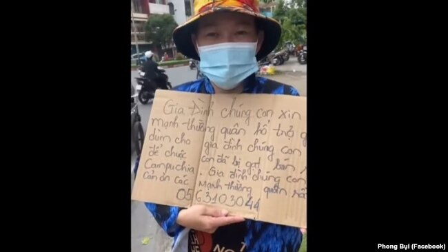 Bà Đồng Thị Ngọc Nga cầm biển trên đường phố TPHCM để xin hỗ trợ tài chính để chuộc đứa con trai bị lừa sang làm việc cho chủ Trung Quốc ở Campuchia.