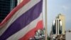 The Thai national flag flutters in the wind as a BTS commuter train rides past in Bangkok on August 24, 2022.