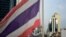 The Thai national flag flutters in the wind as a BTS commuter train rides past in Bangkok on August 24, 2022.