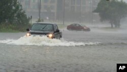 30일 미국 사우스캐롤라이나 찰스톤에 폭우가 쏟아진 가운데 침수된 도로에서 차량들이 운행하고 있다. 