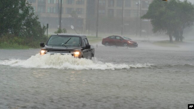 30일 사우스캐롤라이나 찰스톤 시에 강한 폭우가 쏟아진 가운데 자동차들이 물에 잠긴 도로를 지나가고 있다.
