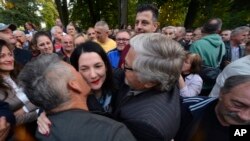 Protesters kiss opposition candidate Jelena Trivic during protest against alleged election fraud in a general elections in the Bosnian town of Banja Luka, 240 kms northwest of Sarajevo, Oct. 6, 2022.